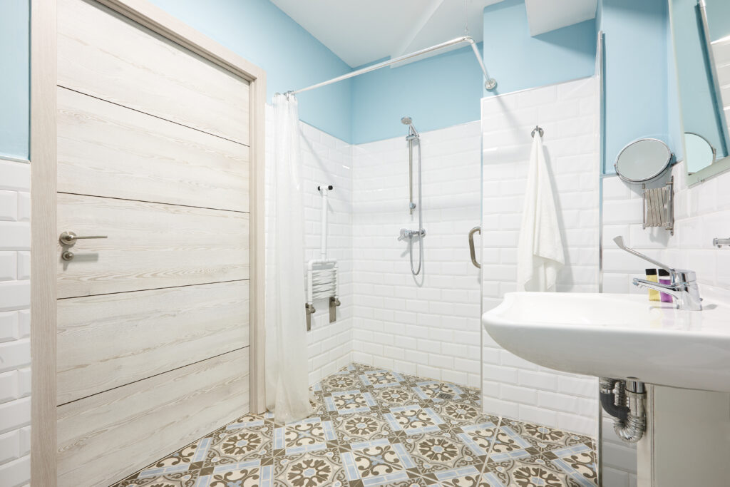 Salle d'eau décorée et adaptée aux personnes handicapées et équipée d'un siège de douche pour PMR. Architecture intérieure d’accessibilité contemporaine.